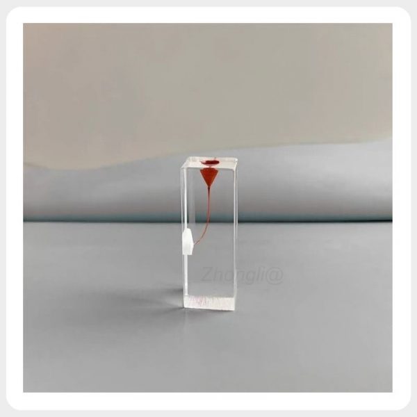 Stained Pulp Chamber Endodontic Training Block Transparent resin endodontic training block with a red-stained pulp chamber and curved simulated root canal